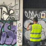 Un miembro de la unidad fotografia una pintada