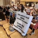 La oficial en el pleno municipal expone una pancarta