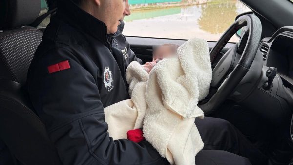 Fotografia del policia local con la bebe